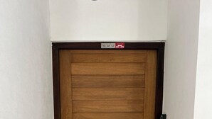 Una puerta de madera con un picaporte metálico y una pequeña señal encima.