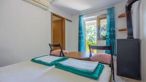Ein Zimmer mit einem Bett, zwei Stühlen, einem Tisch und einem schwarzen Schrank.