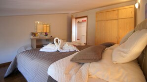 A hotel room with a large bed, a wooden wardrobe, a bedside table with a mirror, and a bathroom visible through an open door. - Charming top floor apartment with sea view and view of the old town of Porec (Porec)