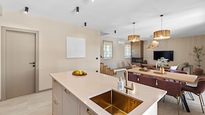 A modern kitchen with a central island, built-in appliances, and pendant lighting. - Impressive villa with panoramic views, private pool, table tennis, table football, playground, baby cot (Pazin)