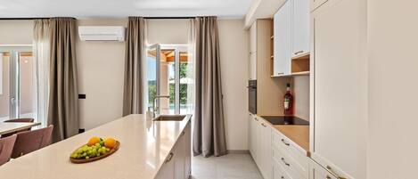 A modern kitchen with a central island, built-in cabinets, and a view to the outdoors.