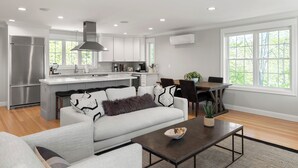 Una cocina moderna con armarios blancos, un refrigerador de acero inoxidable y una isla central.