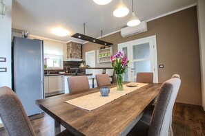 Enjoy meals in the kitchen with oven and dining area with a wooden table and four chairs.
