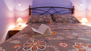 A bed with a floral-patterned bedspread, two bedside lamps, and a book on the bed. - Charming flat just 300 metres from the beach with sea views, washing machine, WiFi (Crikvenica)
