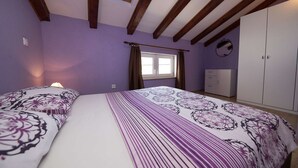 Un dormitorio con dos camas, una ventana, un armario y un tragaluz.