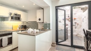Una cocina moderna con una isla central, microondas, horno y cafetera.