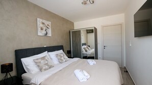 Une chambre d’hôtel avec un lit, un tableau, un miroir et une télévision.