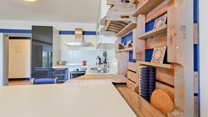 A modern kitchen with a white countertop, wooden shelves, and a built-in stove. - Idyllic flat with sea view, pool, barbecue, washing machine, private car park (Novigrad)