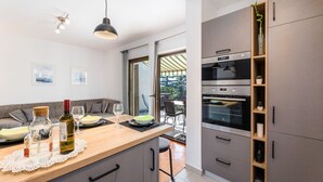 Eine moderne Küche mit Holzarbeitsplatte, integriertem Backofen und Essbereich mit Blick ins Freie.