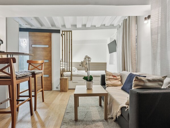 Una sala de estar moderna con una mesa de comedor de madera, un sofá y una mesa baja.