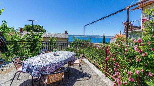 A patio with a table and chairs, overlooking a scenic coastal view. - Nostalgic apartment only 500 meters to the beach with private terrace, sea view, barbecue (Dramalj)