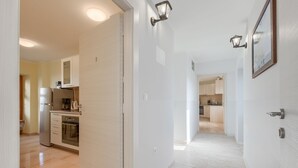 A modern kitchen with stainless steel appliances, a wooden countertop, and a tiled backsplash.