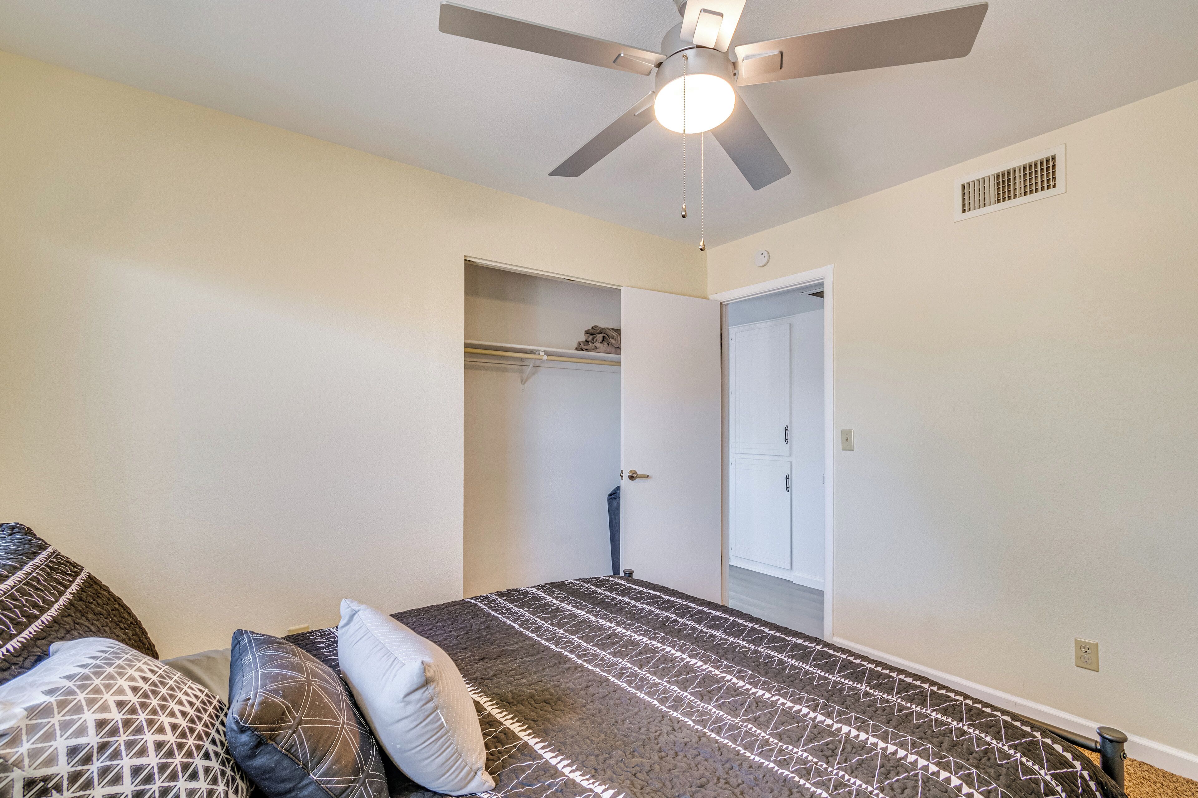 A bedroom with a bed, a closet, and a door.