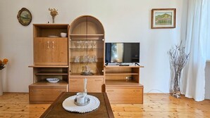 A living room with a wooden cabinet, TV, and a dining table with a placemat. - Comfortable, dog-friendly apartment with private balcony, washing machine, WiFi (Novigrad)
