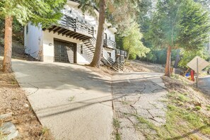 Un immeuble résidentiel doté d’un garage, d’un escalier et d’une allée bordée d’arbres.