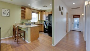 A kitchen with wooden cabinets, a central island, and a refrigerator.
