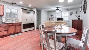 A spacious kitchen with wooden cabinets, a dining area with a round table and chairs, a beige sofa, and a ceiling fan. - Cabin w/ Hot Tub in Valley View: Pets Welcome! (Valley View)