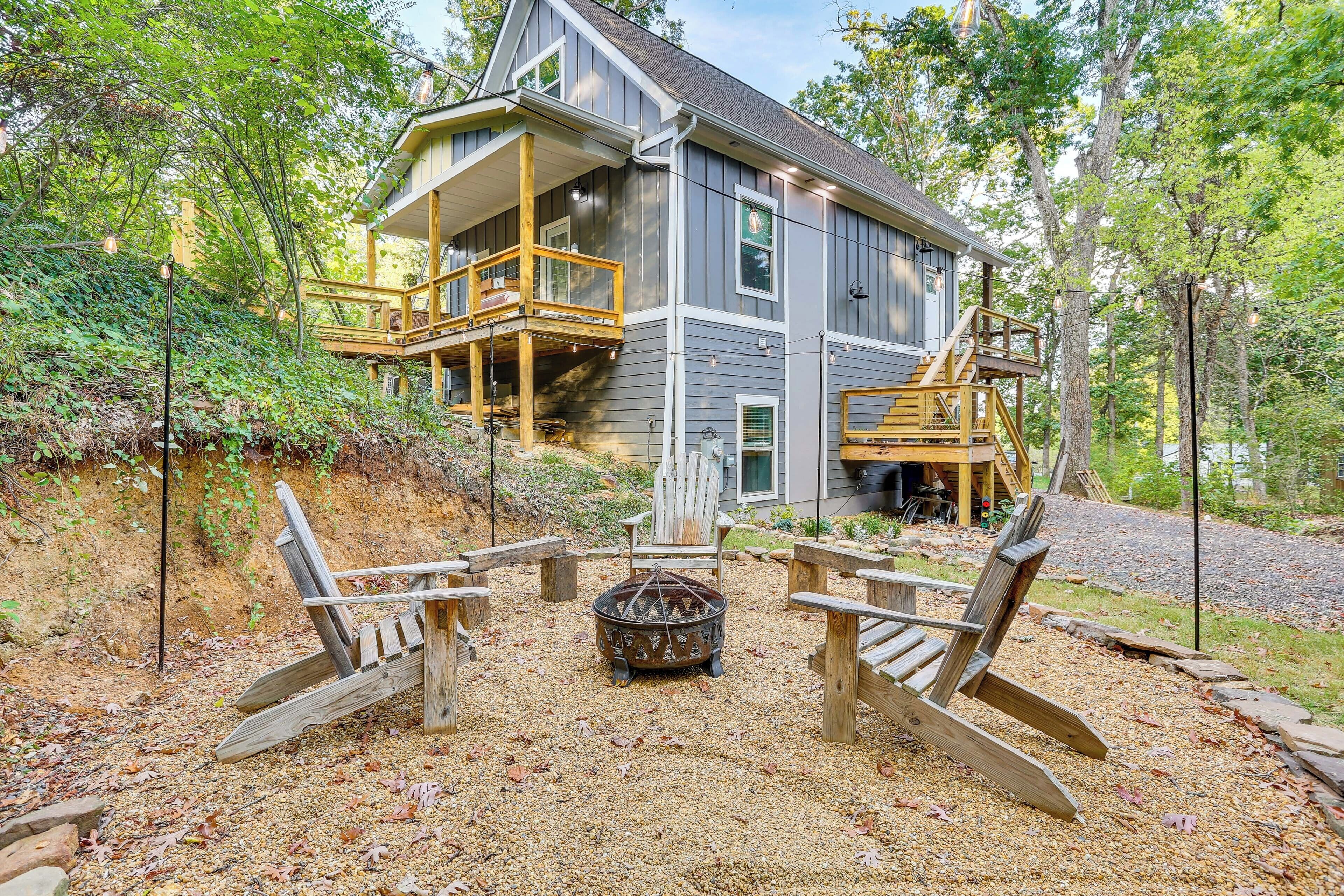 A two-story house with a deck and a fire pit in the backyard.
