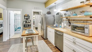 Eine moderne Küche mit Holzarbeitsplatte, Edelstahlgeräten und einem eingebauten Backofen.