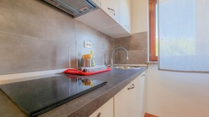 A kitchen with a black countertop, a red tray, a faucet, and a window with a view.