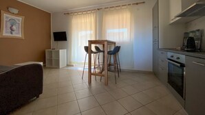 A compact kitchen with a dining area, a TV, and a sofa. - Renovated apartment with private terrace, WiFi, parking near Novigrad (Novigrad)