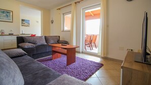 Ein Wohnzimmer mit einer Couch, einem Couchtisch und einem Essbereich mit Stühlen.