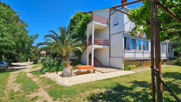A modern two-story house with a balcony, a stone patio, and a car parked nearby. - Affordable, dog-friendly apartment just 100 meters from the beach (Dalja)