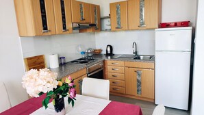 Una cocina moderna con armarios de madera, un lavamanos de acero inoxidable y un refrigerador blanco.