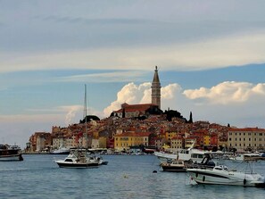 A coastal town with historic buildings, a prominent tower, and boats docked in the harbor. - Bright apartment only 20 minutes to the beach with 2 terraces (Rovinj)