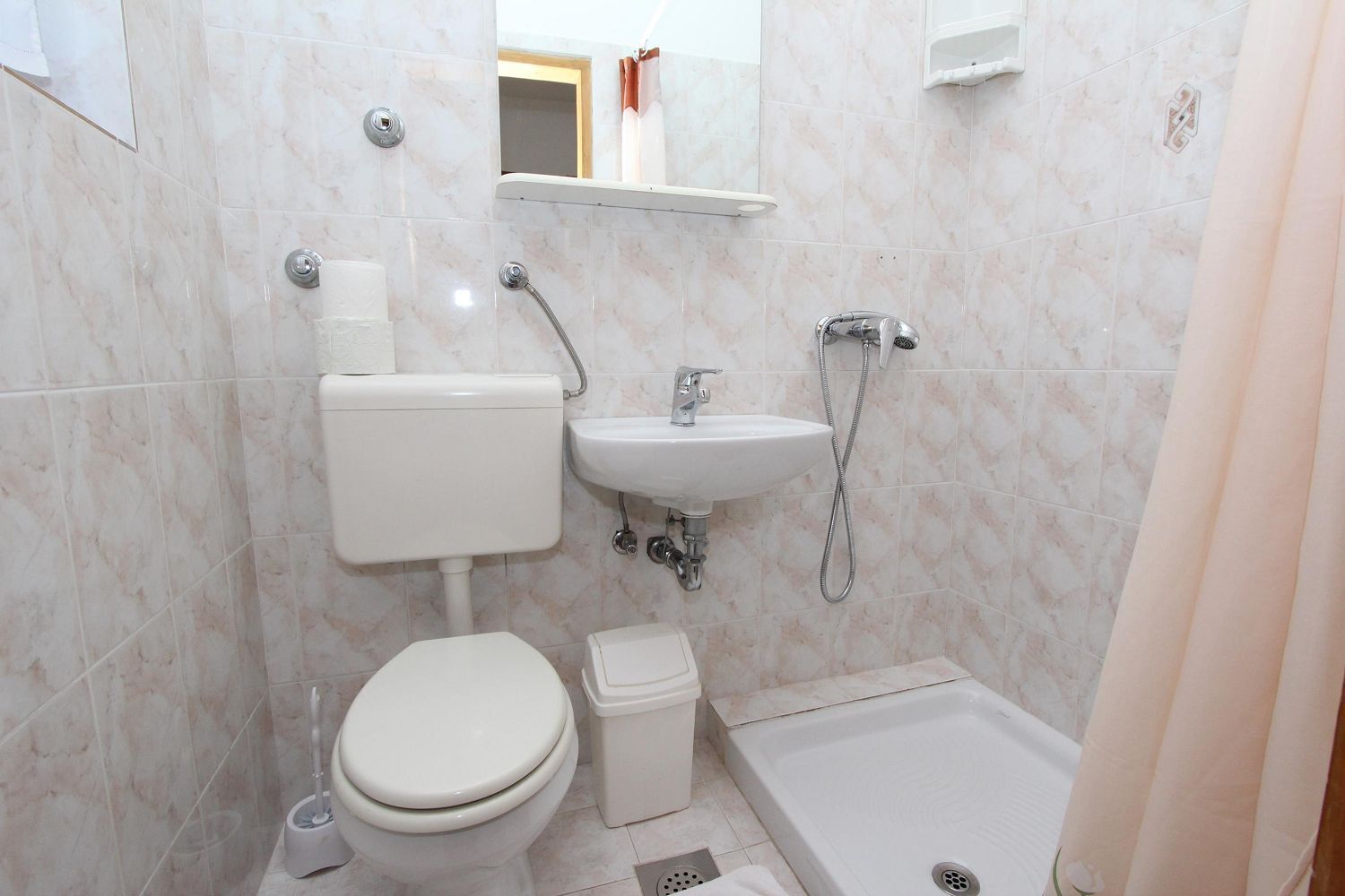 A bathroom with a toilet, sink, shower, and bathtub.