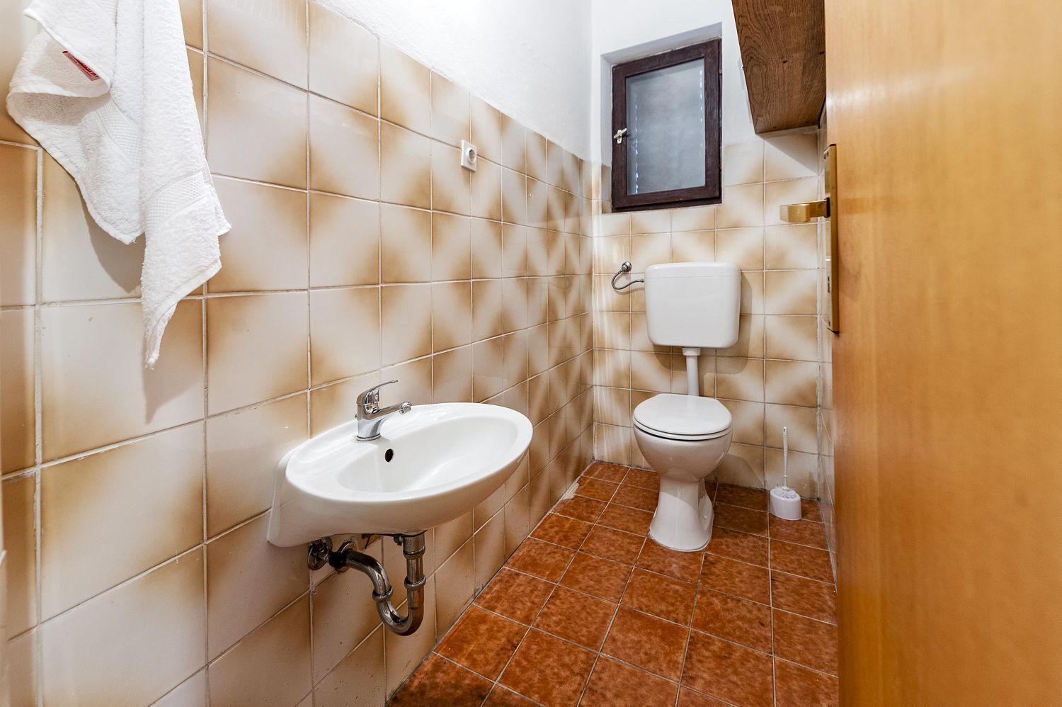 Une salle de bain équipée d’un lavabo, de toilettes et d’un porte-serviettes.