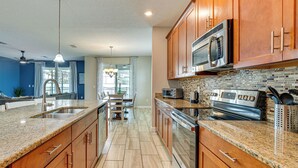 Eine moderne Küche mit Granit-Arbeitsplatten, Edelstahlgeräten und Holzschränken.
