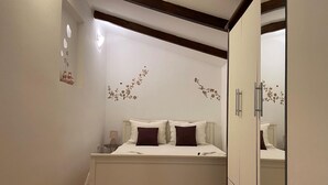 A bedroom with a bed, a nightstand, a dresser, and a mirror. - Mediterranean apartment with barbecue area, sun loungers in the garden, private parking, WiFi (Rovinj)