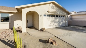 A single-story house with a garage, a small patio, and a cactus in the foreground. - 3 Mi to London Bridge: Home w/ Patio & Grill! (Lake Havasu City)
