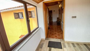 Un pasillo con techo de madera, pared amarilla y suelo estampado.