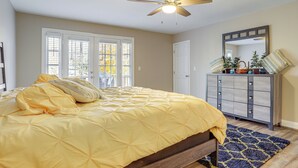 A bedroom with a bed, a ceiling fan, a dresser, and a mirror. - Cozy Country Livin! Gem 17 Mi to Lakepoint Sports (Woodstock)