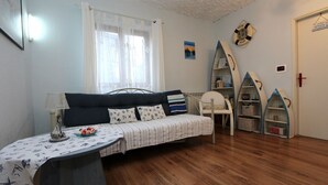 A cozy room with a bed, a table with a lamp, a chair, and a bookshelf. - Idyllic flat just 200 metres from the beach with taxi boat connection to Rovinj (Rovinj)