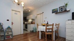 A compact kitchen with a dining area, wooden flooring, and a white ceiling. - Idyllic flat just 200 metres from the beach with taxi boat connection to Rovinj (Rovinj)