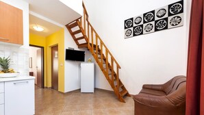 Eine moderne Küche mit einer Holztreppe, einem weißen Kühlschrank und einem braunen Ledersofa.