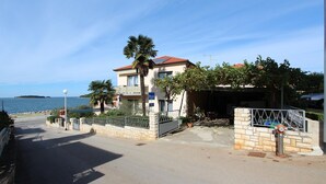 Un edificio costero con balcón, garaje y vistas al mar.