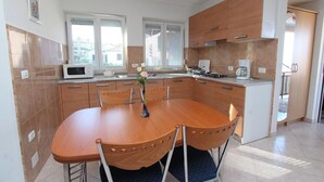 Una cocina moderna con una mesa de comedor, sillas y un jarrón de flores.