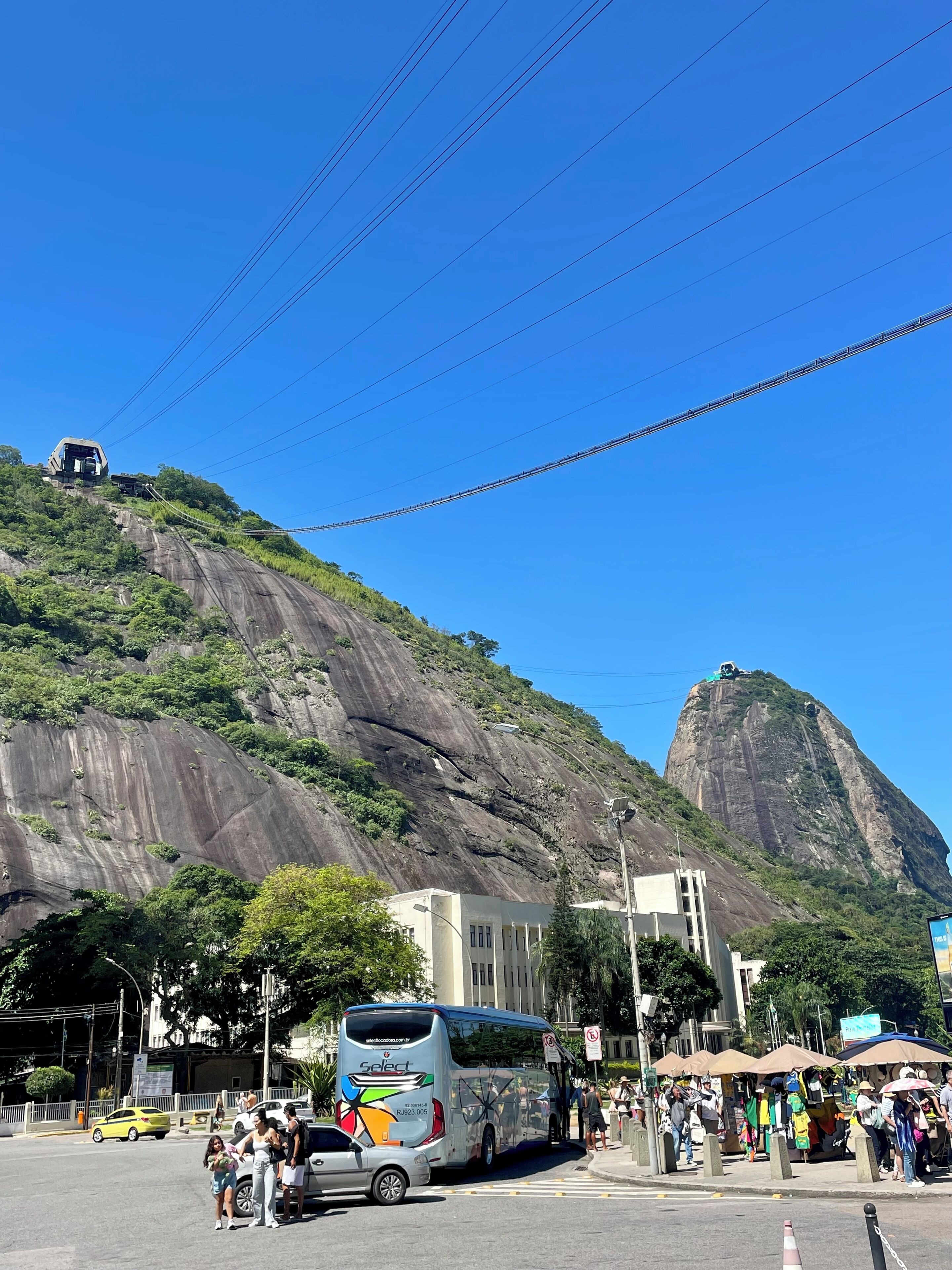 A bus at a bus stop with a mountainous background.