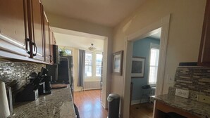 A kitchen with wooden cabinets, a granite countertop, and a trash can. - 3-bedroom D.C. row house with parking, Metro across the street! WOW (Washington)