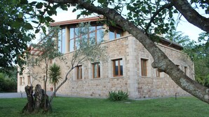 A stone building with multiple windows and a sloped roof.