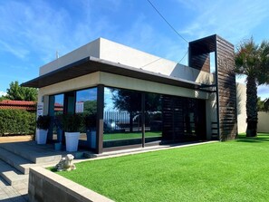 Situated on a well-maintained lawn, this building features large windows and a unique exterior design.