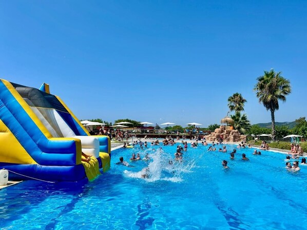 Enjoy a lively poolside experience with a large slide and comfortable lounge seating.