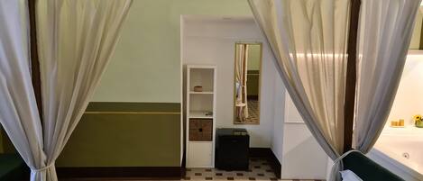 Une chambre d’hôtel avec un lit, une petite table de chevet, un miroir et une armoire.