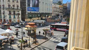 A busy urban square with a bus, parked cars, and pedestrians. - Toscano Palace Luxury Rooms Catania (Catania)