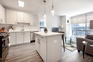 Deluxe appartement, keuken | Privékeuken | Een koelkast met diepvriezer, een microgolfoven, een oven, een kookplaat