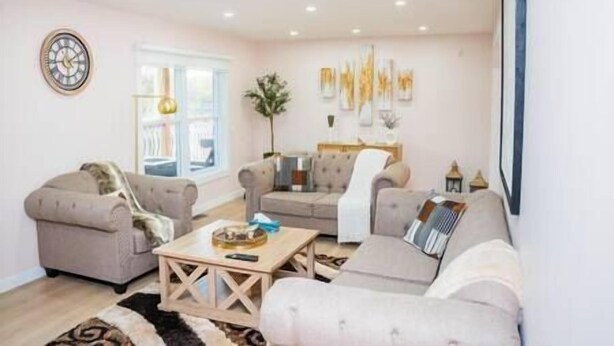 A living room with a sofa set, a coffee table, and a wall clock.